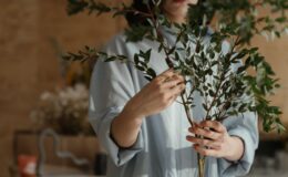 person in white long sleeve shirt holding green plant