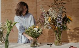 woman in white dress shirt holding bouquet of flowers