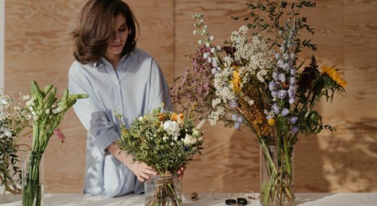 woman in white dress shirt holding bouquet of flowers