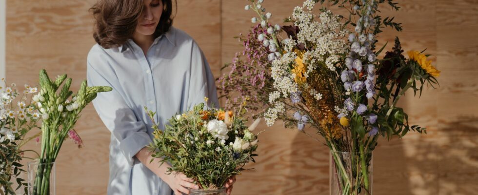 woman in white dress shirt holding bouquet of flowers