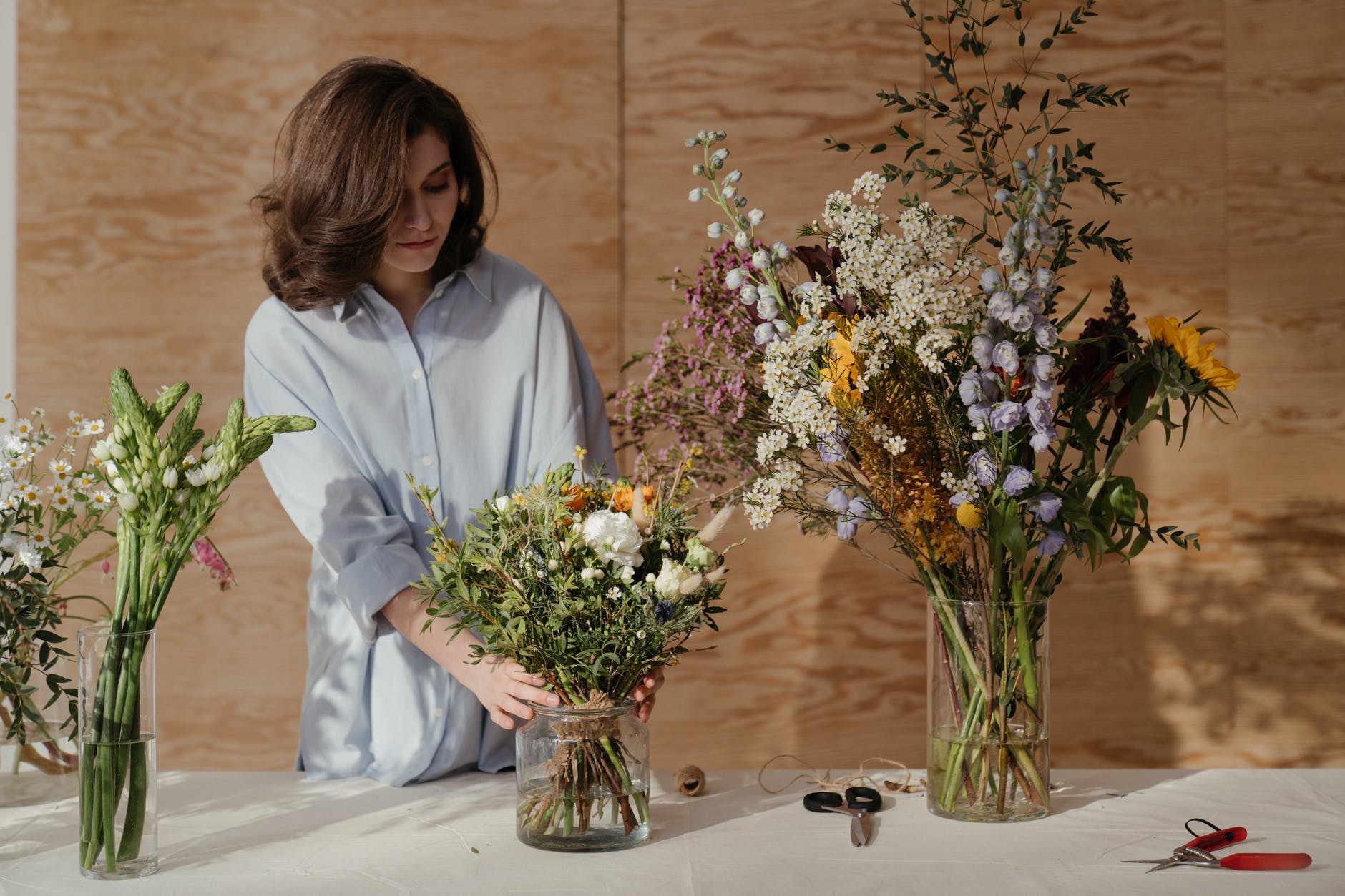 woman in white dress shirt holding bouquet of flowers