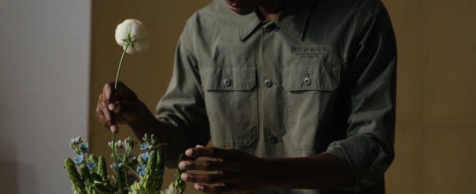 man in gray dress shirt holding white flower