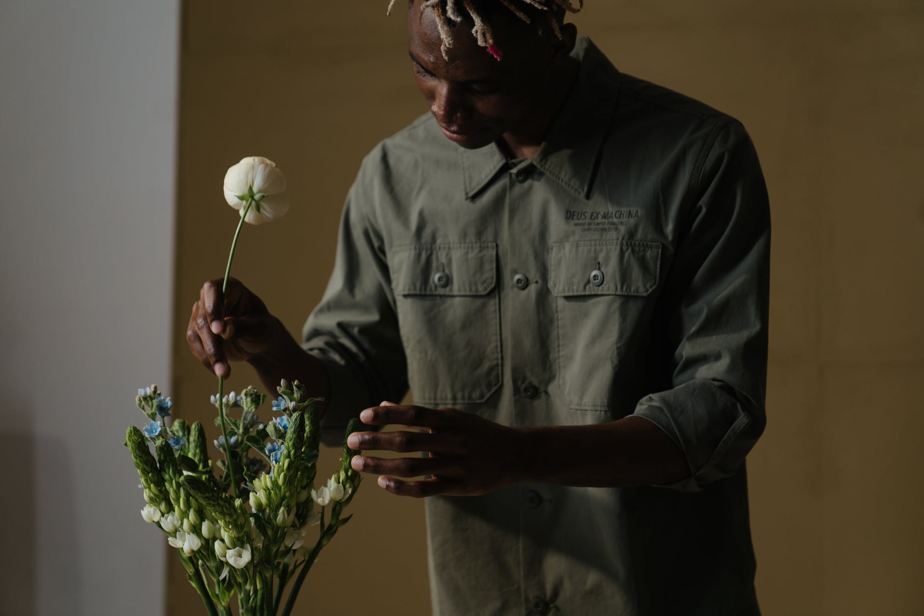 man in gray dress shirt holding white flower