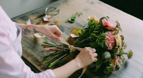 person arranging a bouquet of flowers