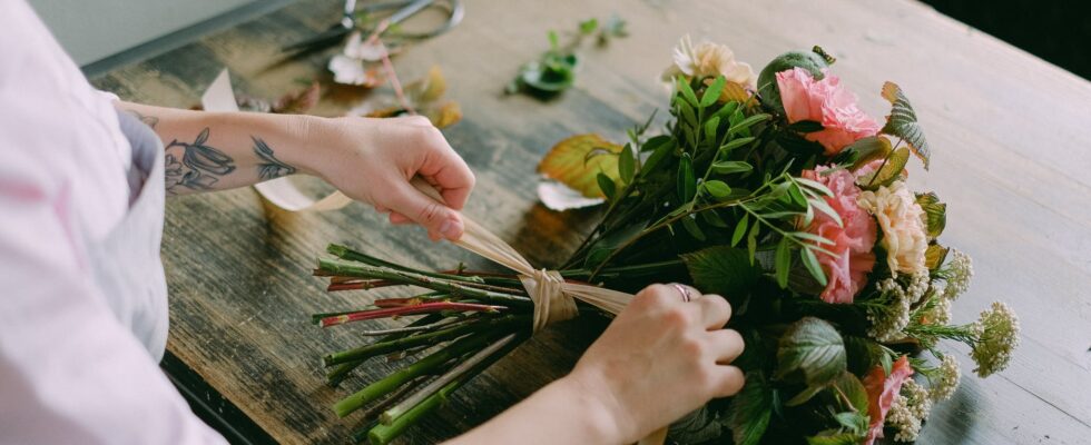 person arranging a bouquet of flowers