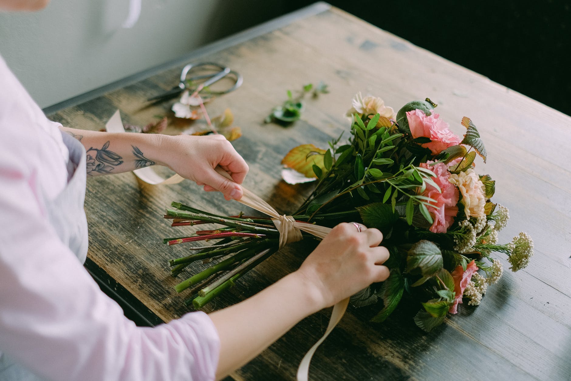 person arranging a bouquet of flowers