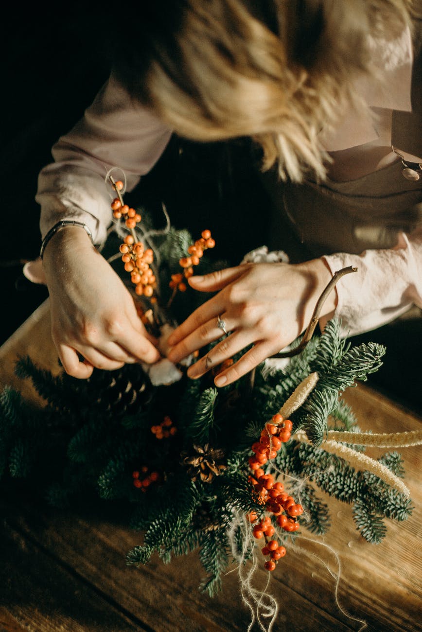 person fixing green christmas tree